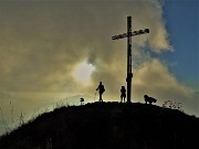 05 La croce di vetta (1366 m) in controluce tra nubi sparse vaganti 